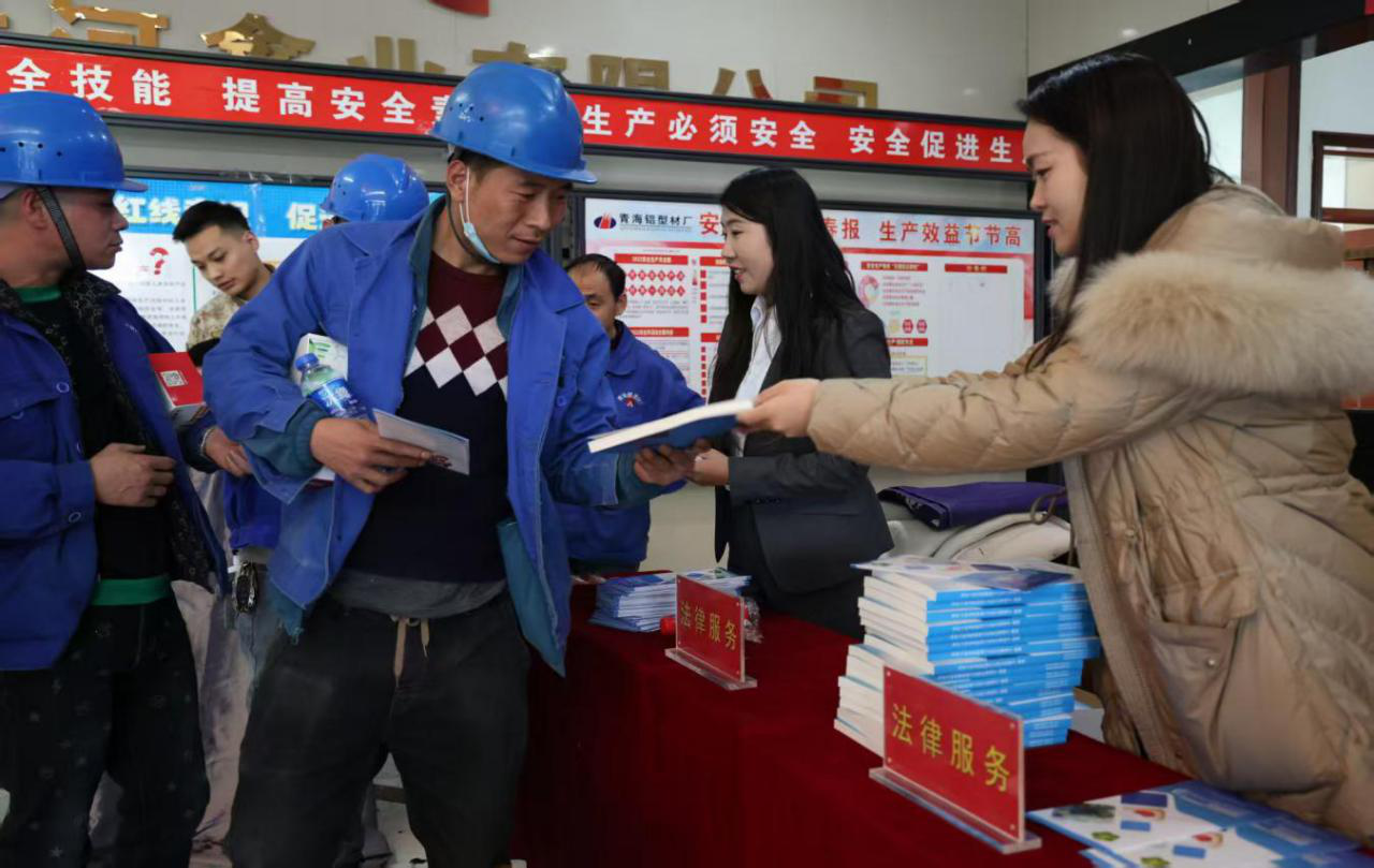 图为为残疾人发放法律法规汇编和便民知识手册现场
